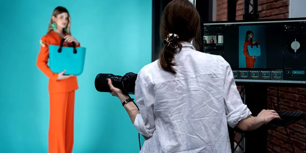 Fotograf robiący zdjęcia modelce z torebką w studiu Orbitvu