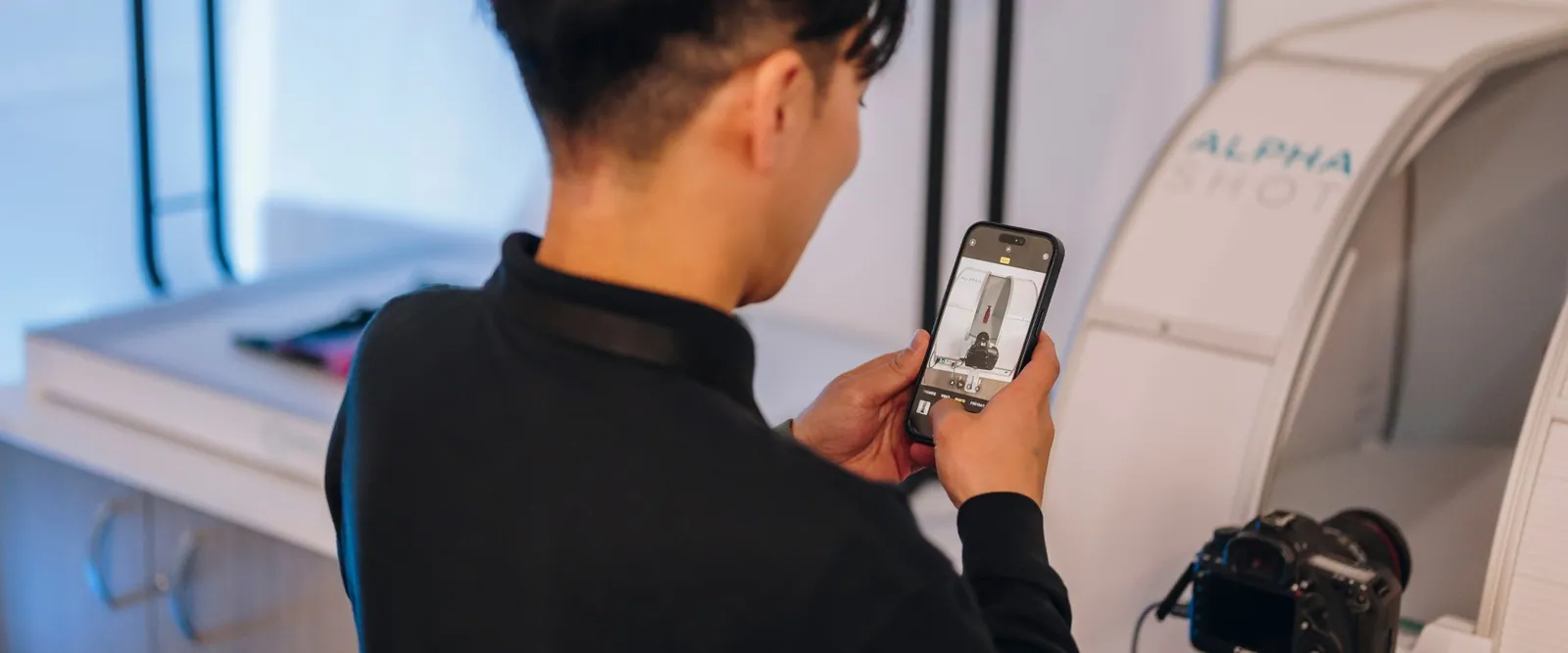 Gość fotografujący smartfonem studio Orbitvu Alphashot podczas FIN Studio Event