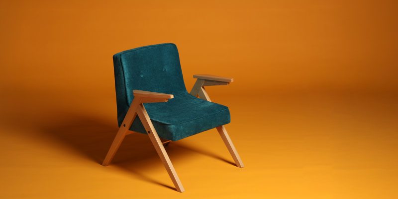 Stylish turquoise chair shot on a yellow background