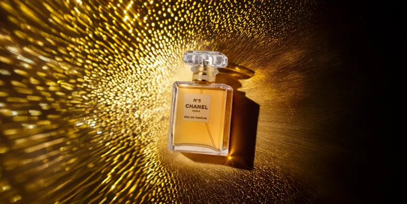 Zdjęcie produktowe flakonu perfum na tle złotego światła