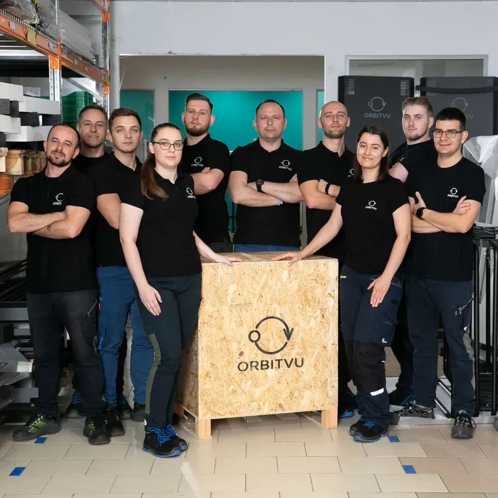 Zespół produkcji i logistyki Orbitvu pozuje z brandowaną drewnianą skrzynią
