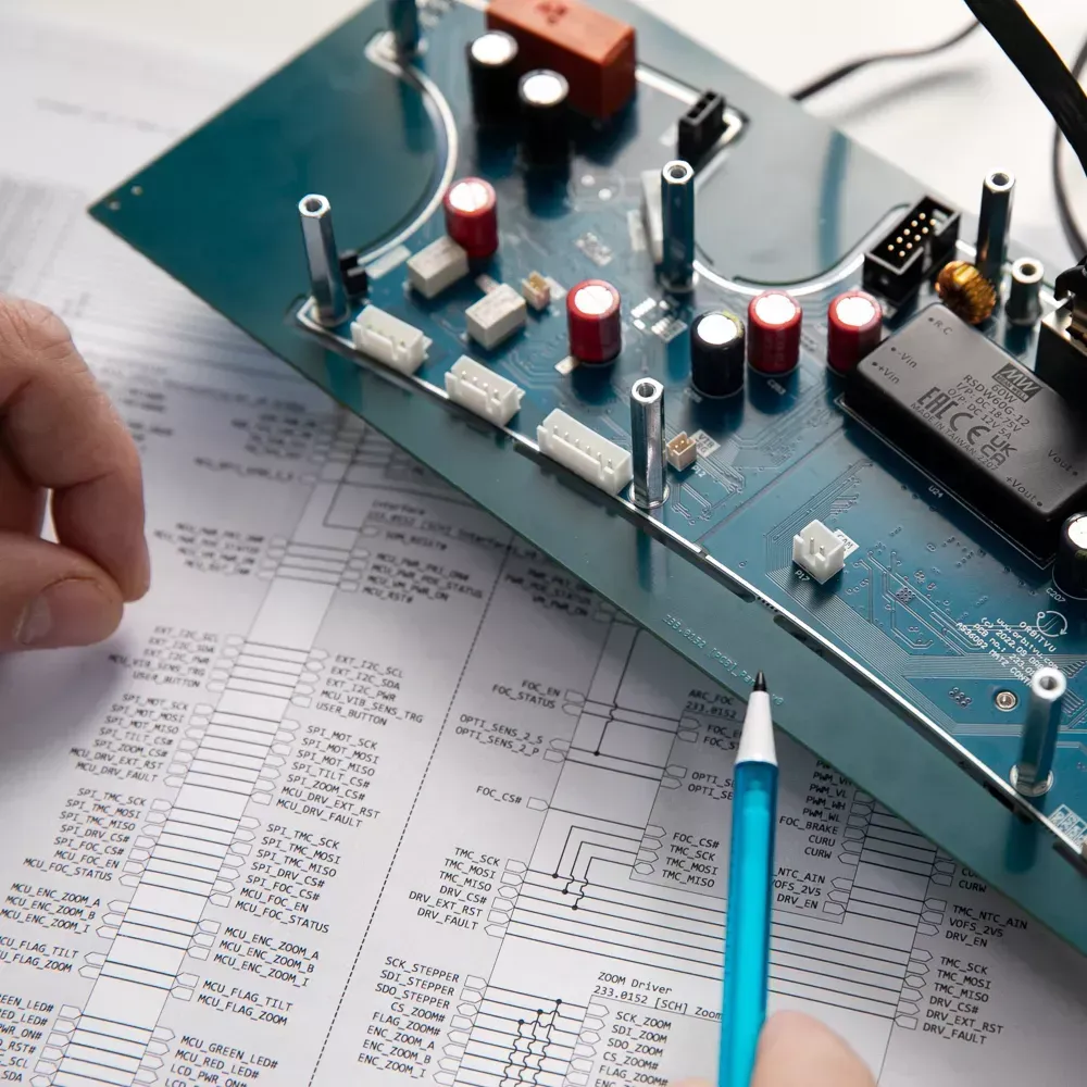 Inżynier analizujący płytkę elektroniczną i schemat