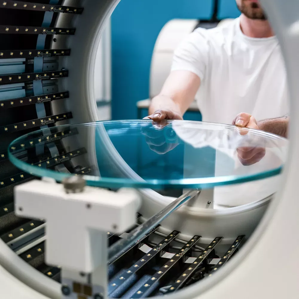 Technik umieszczający szklaną platformę obrotową w zautomatyzowanym studiu fotograficznym